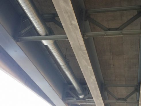 Conduites de distribution d'eau pré isolées avec mousse de polyuréthane et revêtement d'acier galvanisé spiral circulant sous un pont.