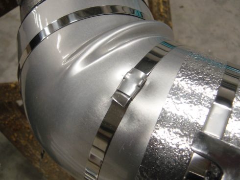 Bandes d'acier inoxydable sur coude pré isolé.