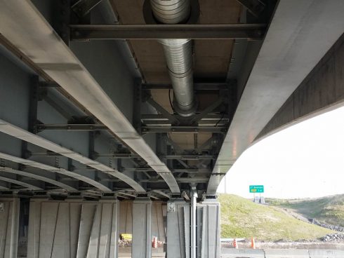 Conduites de distribution d'eau pré isolées avec mousse de polyuréthane et revêtement d'acier galvanisé spiral circulant sous un pont.